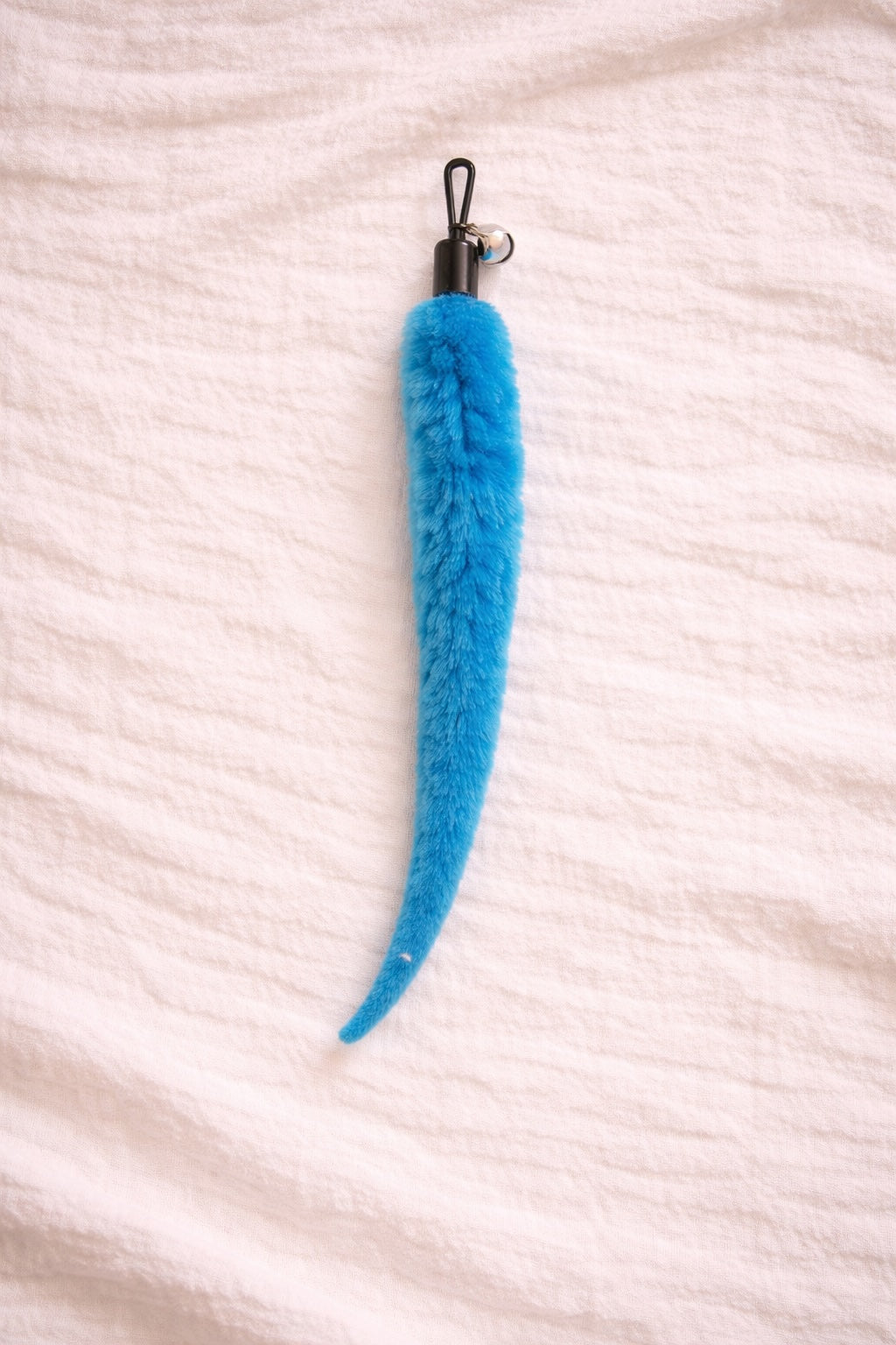 Blue furry cat toy attachment with bell and clip connector