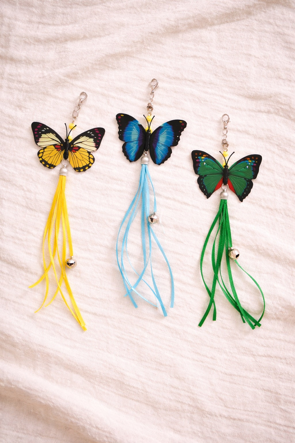 Three butterfly cat wand attachments with colourful tassels