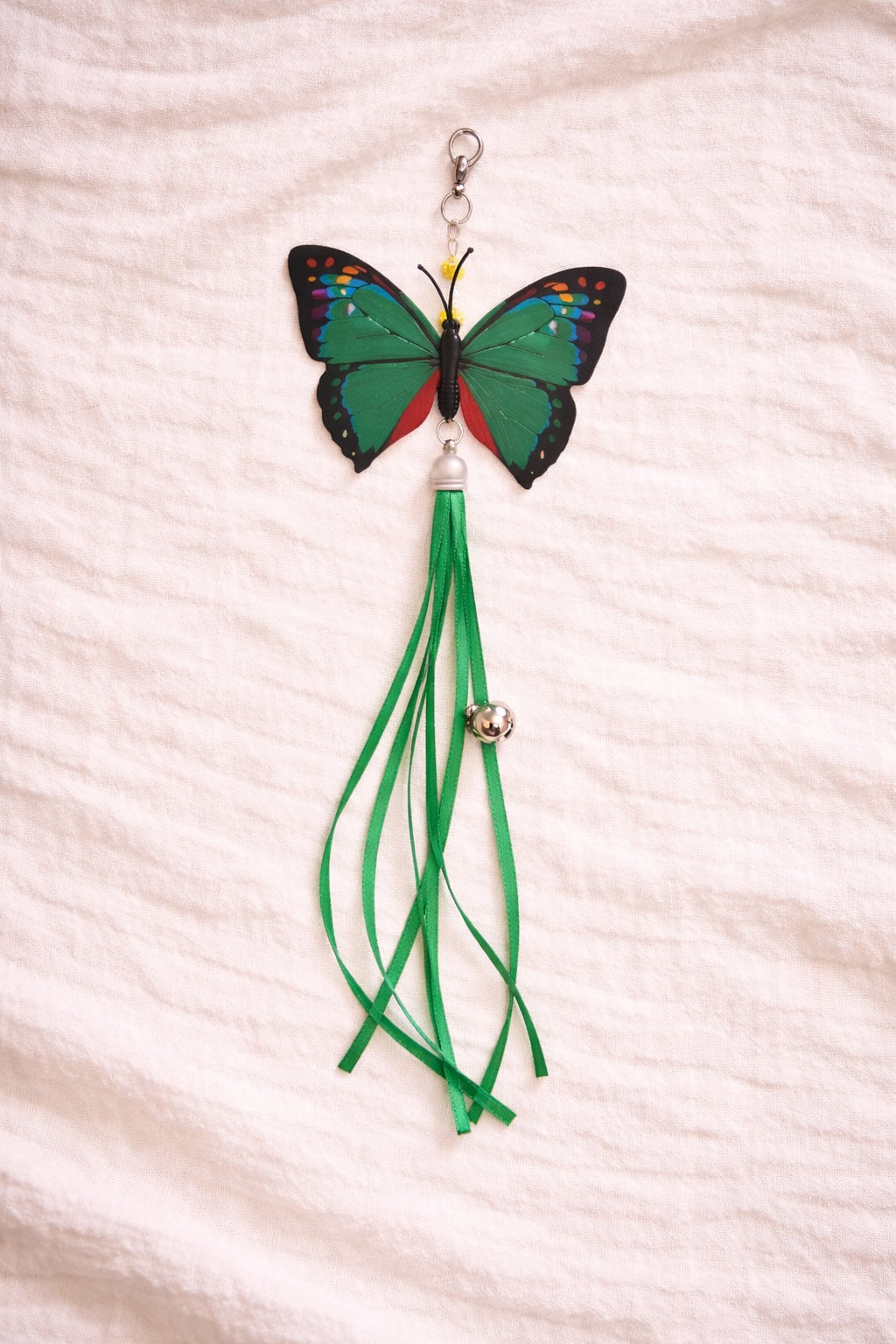 Green butterfly cat toy attachment with ribbon tail and bell