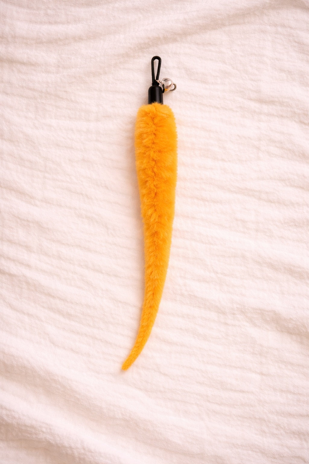 Orange furry cat toy attachment with bell and clip connector