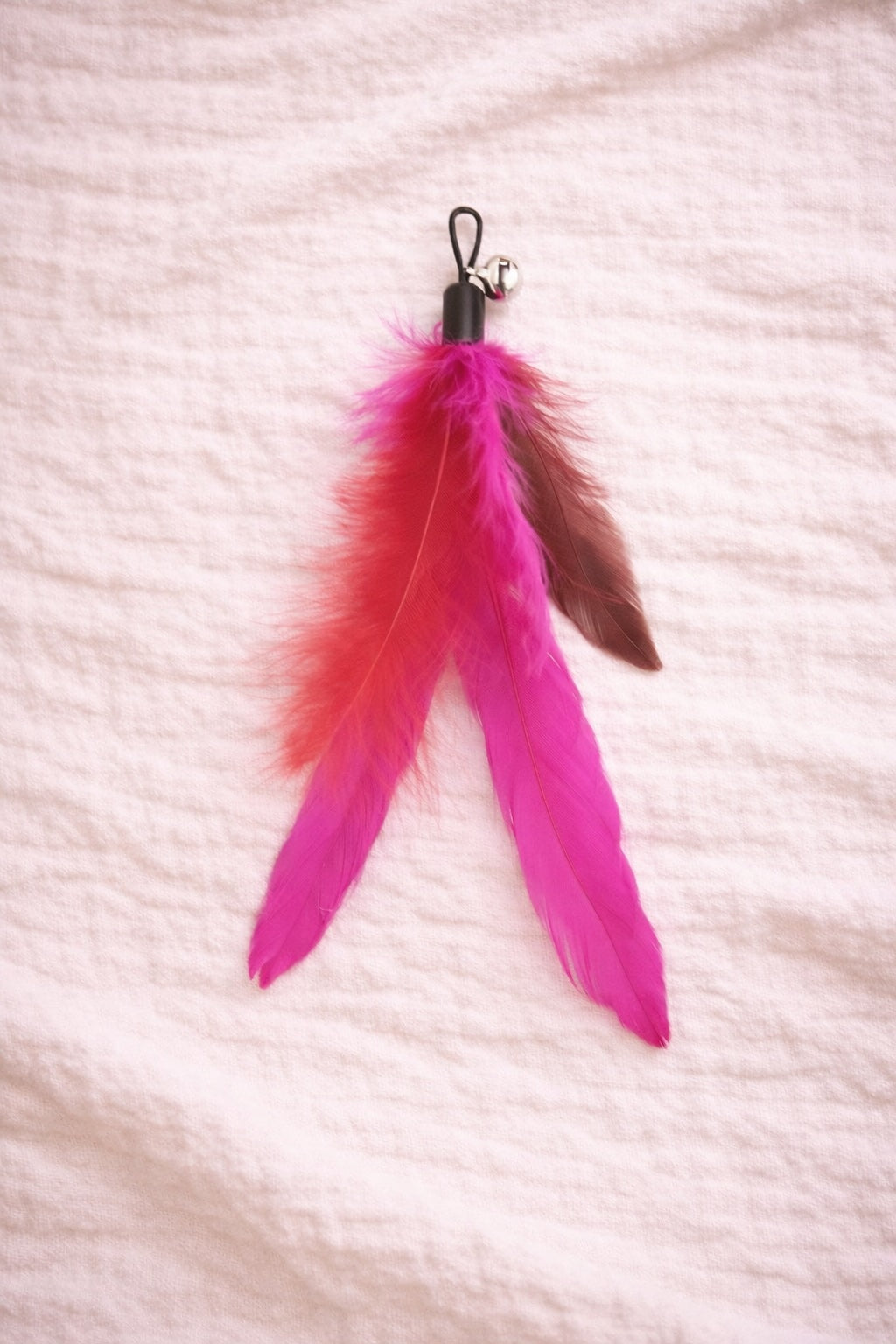 Pink feather cat toy attachment with red base detail and clip