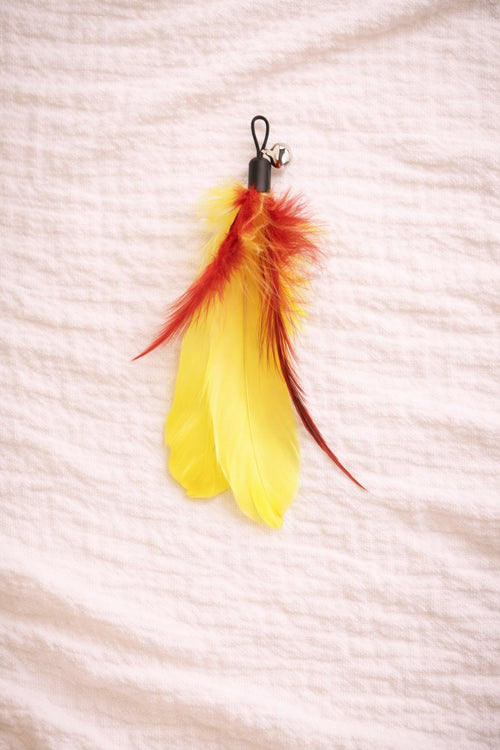 Yellow feather cat toy with red detail and clip connector
